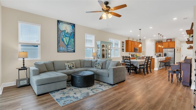 living room with recessed lighting, light wood-style flooring, baseboards, and a ceiling fan
