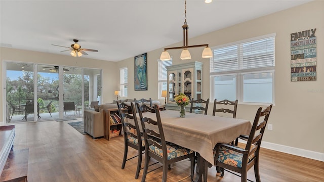 dining space featuring baseboards, ceiling fan, and light wood finished floors