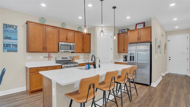 kitchen with a sink, brown cabinetry, and stainless steel appliances