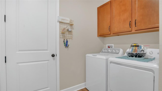 laundry room featuring cabinet space, washing machine and dryer, and baseboards