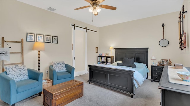 bedroom with visible vents, ceiling fan, a barn door, and carpet floors