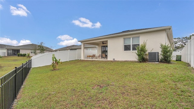 back of house featuring stucco siding, a fenced backyard, a yard, ceiling fan, and a patio area