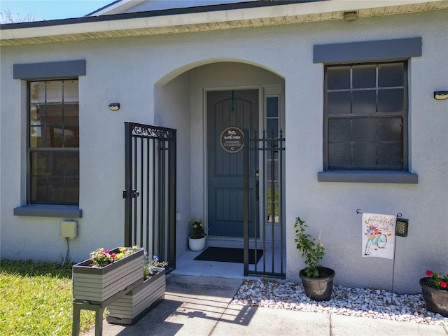 doorway to property featuring stucco siding