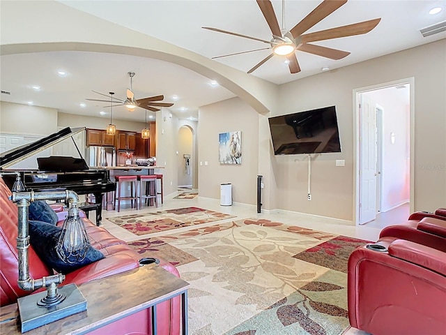 living area with recessed lighting, arched walkways, visible vents, and ceiling fan