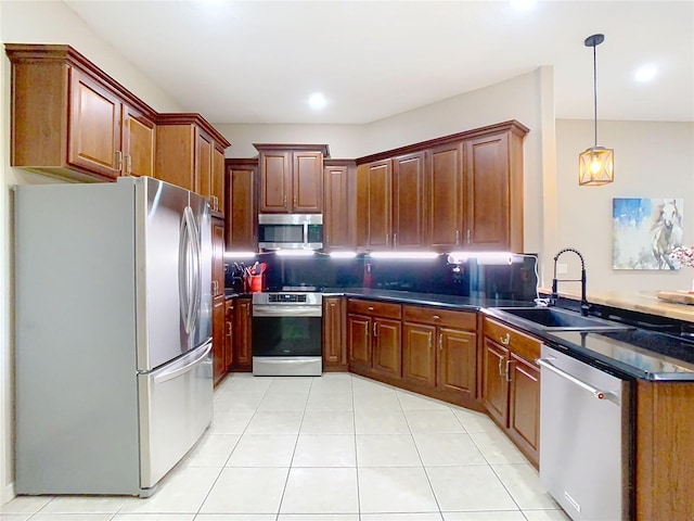 kitchen with dark countertops, backsplash, appliances with stainless steel finishes, a peninsula, and a sink