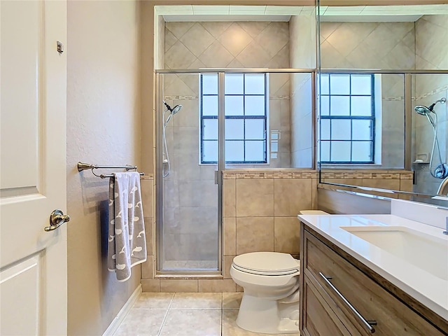 full bath featuring tile patterned flooring, a healthy amount of sunlight, a stall shower, and vanity