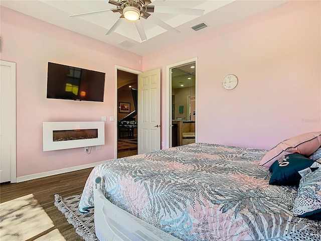 bedroom featuring visible vents, baseboards, wood finished floors, and a ceiling fan