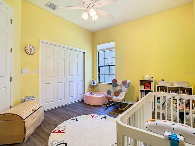 bedroom featuring a ceiling fan, wood finished floors, visible vents, and a closet