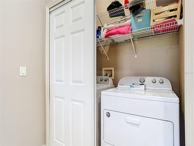 clothes washing area with washing machine and clothes dryer and laundry area