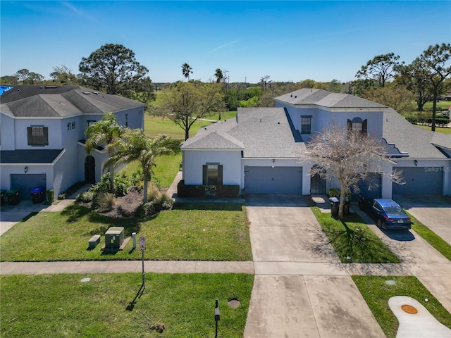 mediterranean / spanish-style home with a front yard, roof with shingles, an attached garage, stucco siding, and concrete driveway