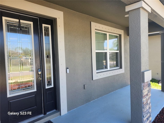 doorway to property featuring stucco siding