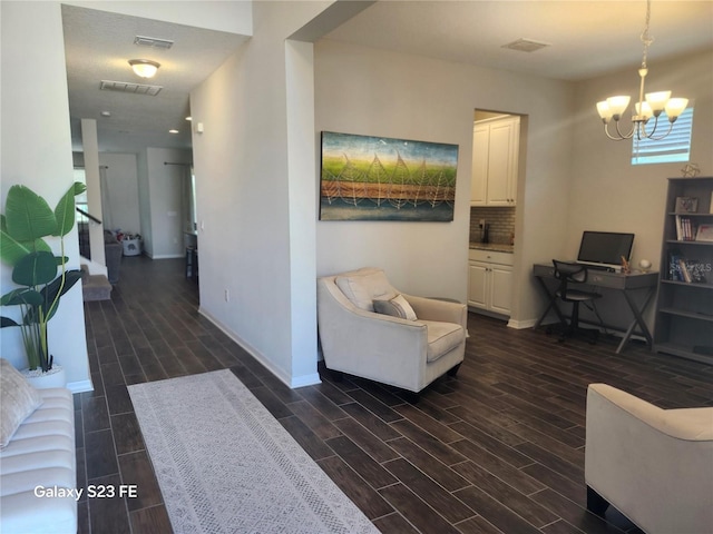 interior space with wood tiled floor, visible vents, baseboards, and an inviting chandelier