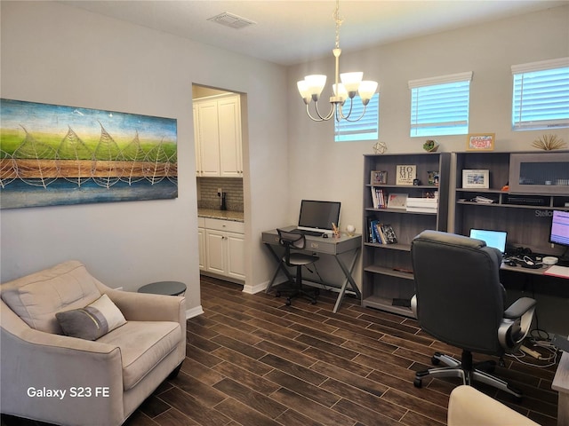 office area featuring a chandelier, wood finish floors, visible vents, and baseboards