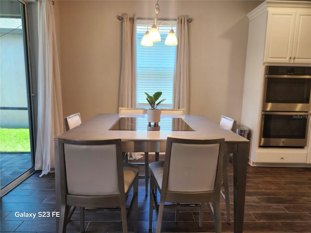 dining space with a chandelier, wood tiled floor, and a healthy amount of sunlight