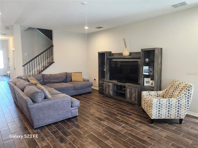 living area with baseboards, visible vents, wood tiled floor, stairs, and a textured ceiling