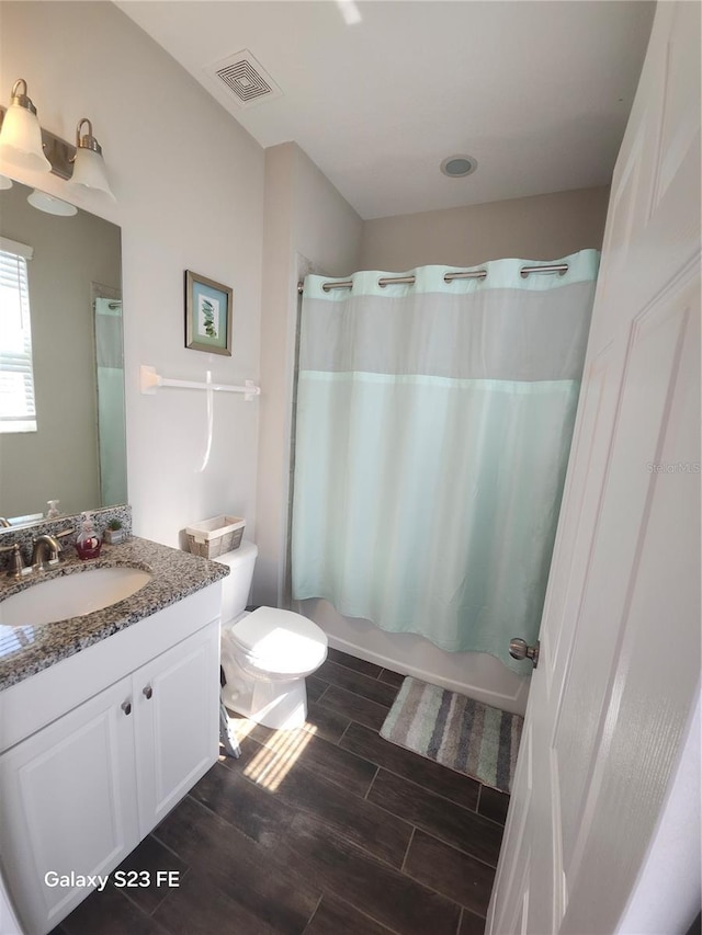 full bathroom featuring visible vents, toilet, shower / bath combo with shower curtain, vanity, and wood finish floors