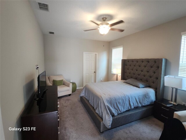 carpeted bedroom with ceiling fan and visible vents