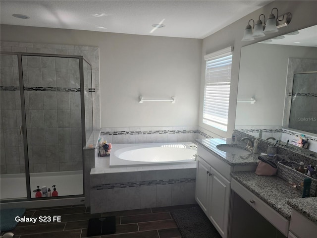 bathroom featuring a stall shower, vanity, and a bath