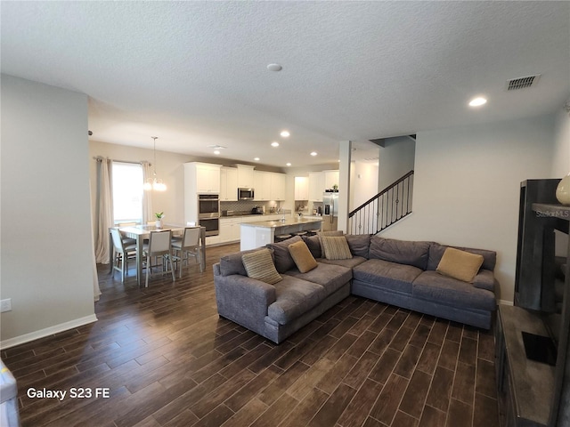 living area with baseboards, visible vents, stairway, dark wood-type flooring, and recessed lighting