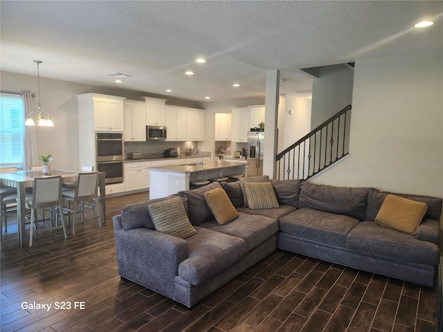 living room featuring a chandelier, a textured ceiling, recessed lighting, stairway, and wood tiled floor