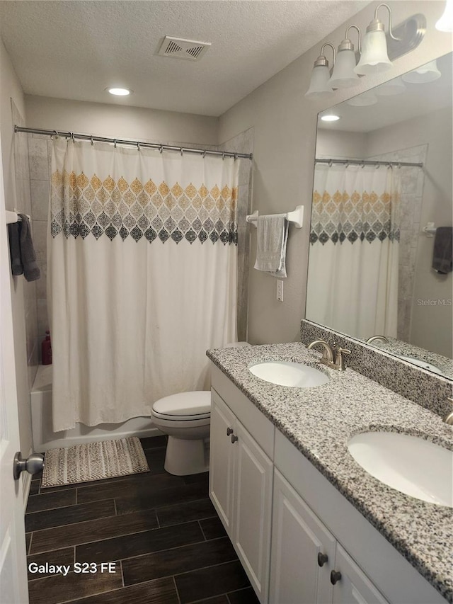 bathroom featuring wood tiled floor, visible vents, a sink, and toilet