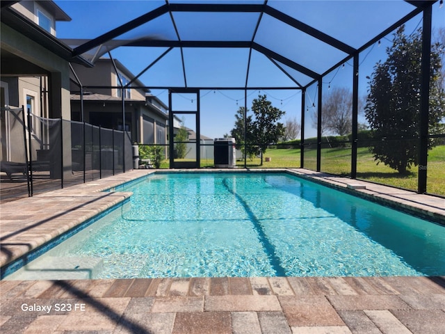 outdoor pool with glass enclosure, a yard, and a patio