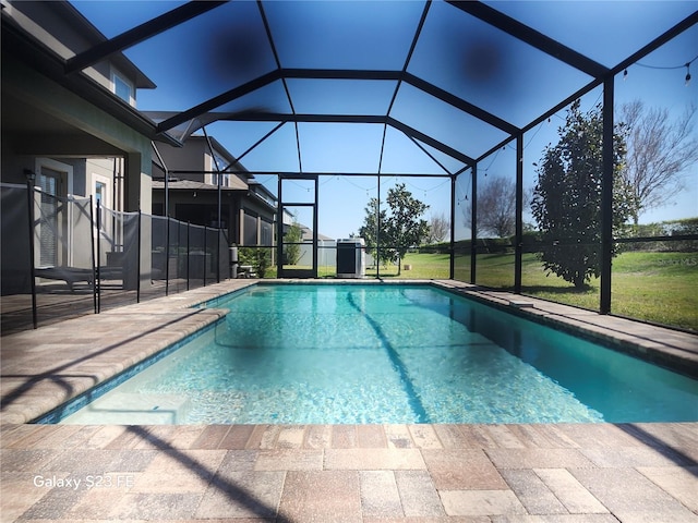 pool featuring a lanai, a patio area, and a yard