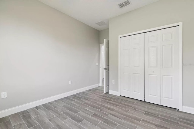 unfurnished bedroom with wood tiled floor, visible vents, and baseboards