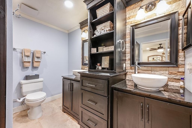 bathroom featuring ornamental molding, two vanities, a sink, and toilet