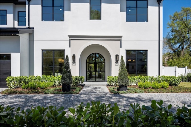 entrance to property with stucco siding and fence