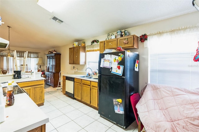 kitchen featuring visible vents, white dishwasher, freestanding refrigerator, a sink, and light countertops