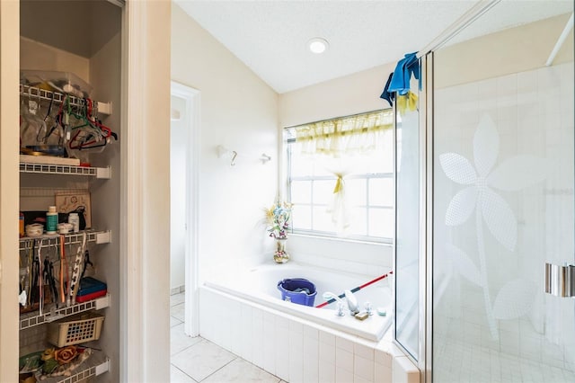 bathroom with tile patterned floors, a garden tub, and a shower stall