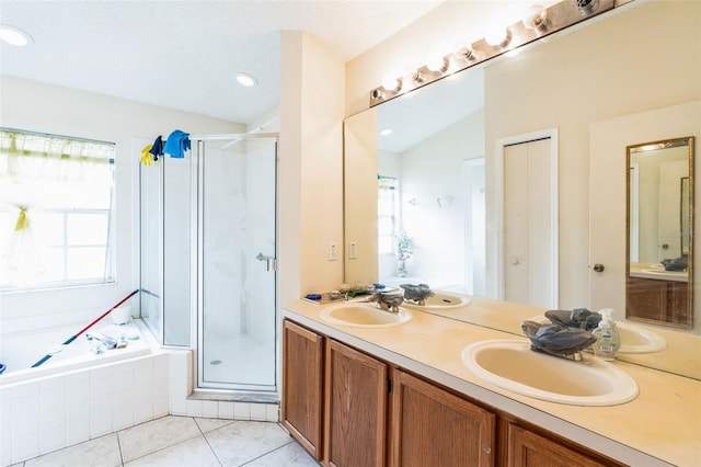 full bathroom with tile patterned floors, a stall shower, a garden tub, and a sink