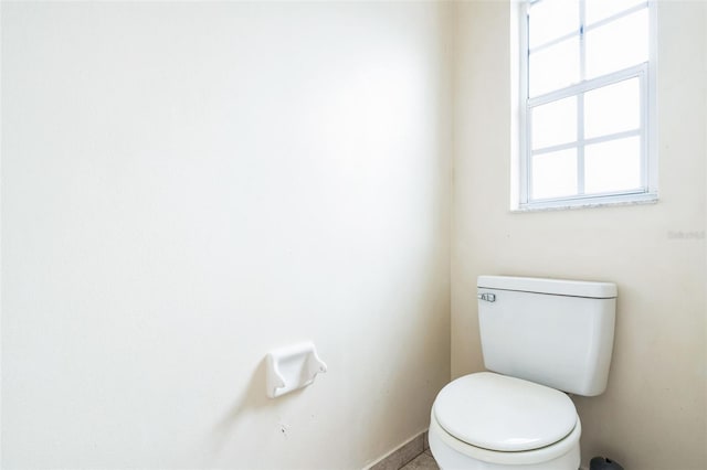 bathroom with baseboards and toilet