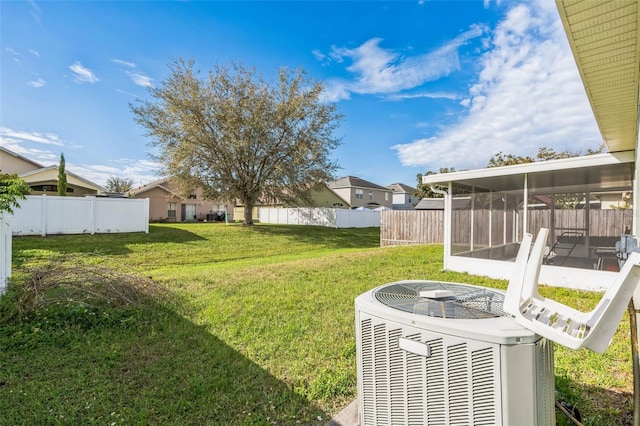 view of yard with cooling unit, a sunroom, and fence