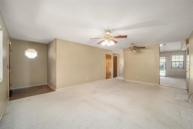 spare room featuring carpet flooring, ceiling fan, a textured ceiling, and baseboards