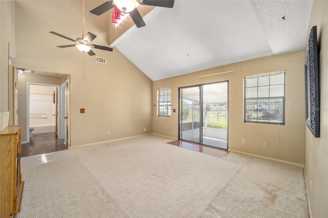 spare room with visible vents, high vaulted ceiling, a textured ceiling, carpet, and baseboards