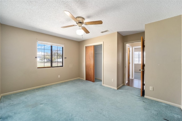 unfurnished bedroom with visible vents, a closet, carpet flooring, baseboards, and ceiling fan