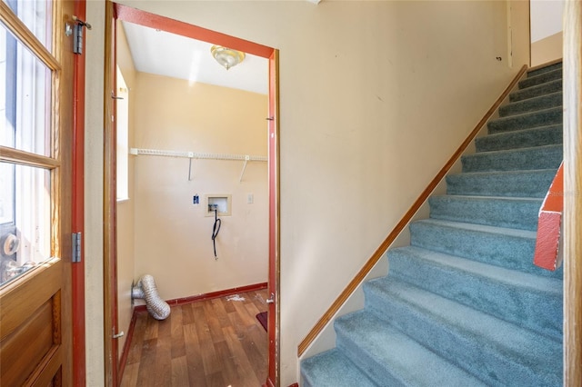 stairway with wood finished floors and baseboards