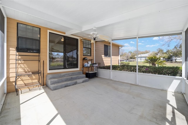 unfurnished sunroom with beamed ceiling and ceiling fan