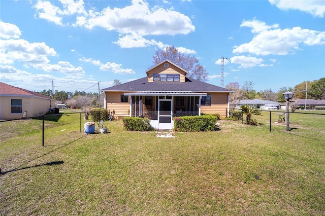 back of house with fence, a lawn, and a sunroom