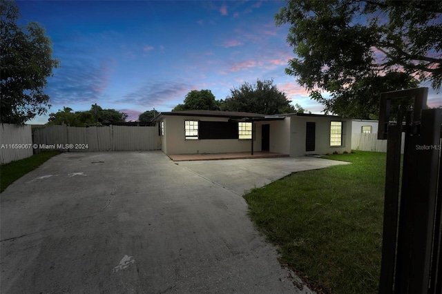 view of front facade featuring a patio area, a front yard, fence, and stucco siding