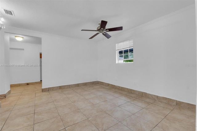 unfurnished room with light tile patterned flooring, a ceiling fan, baseboards, visible vents, and crown molding