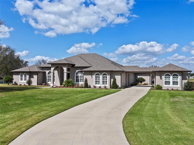 view of front of house with concrete driveway, a front lawn, and stucco siding