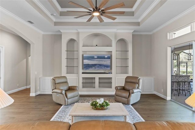 living area featuring wood finished floors, built in shelves, and a raised ceiling