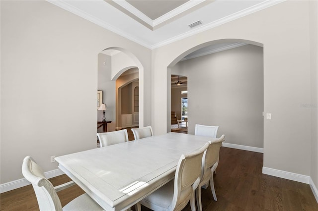 dining space featuring crown molding, visible vents, a ceiling fan, wood finished floors, and baseboards