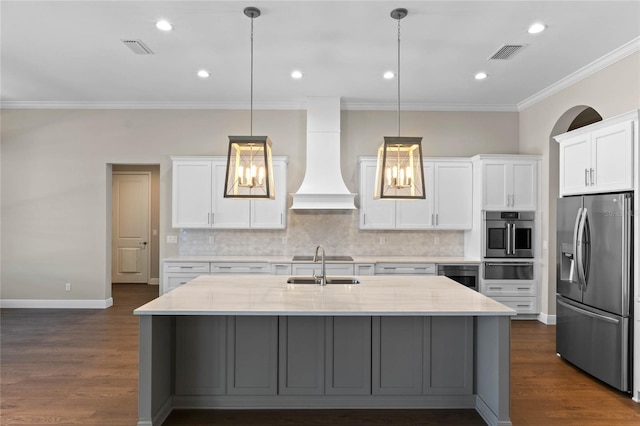 kitchen featuring dark wood-style floors, stainless steel fridge, visible vents, and custom range hood