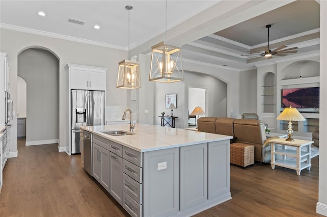 kitchen with visible vents, arched walkways, stainless steel appliances, built in shelves, and a sink