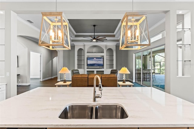 kitchen featuring built in features, visible vents, ornamental molding, light stone countertops, and a sink