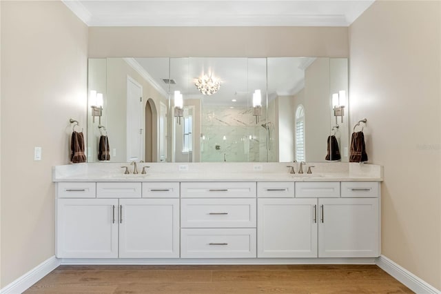 bathroom with ornamental molding, a sink, a marble finish shower, and wood finished floors